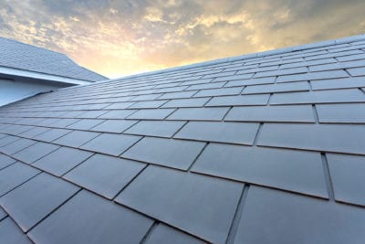 Slate roof against blue sky, Gray tile roof of construction house