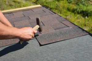 Roofer installing asphalt shingles